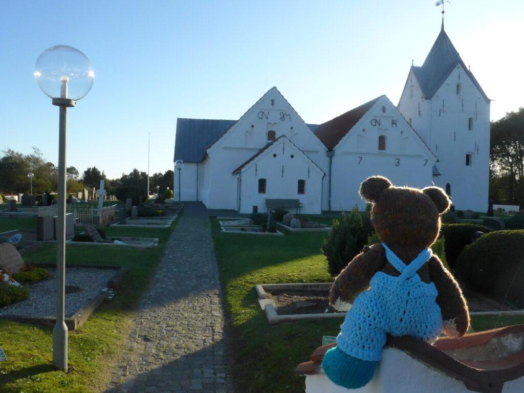 Strickteddy Brummla schaut auf die weiße Kirche von Römö
